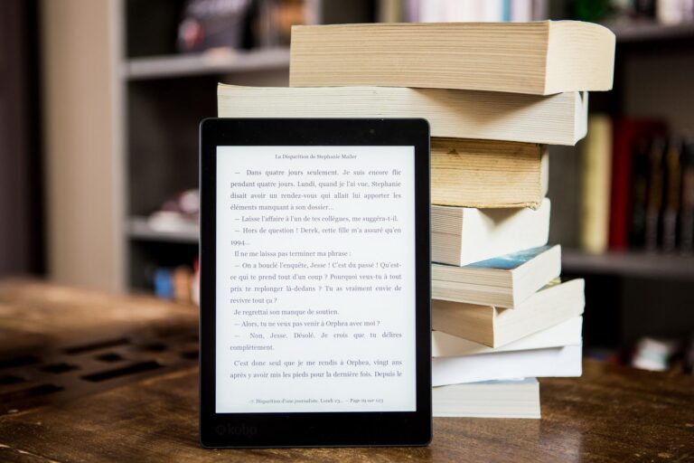 eBook reader davanti a una pila di libri cartacei